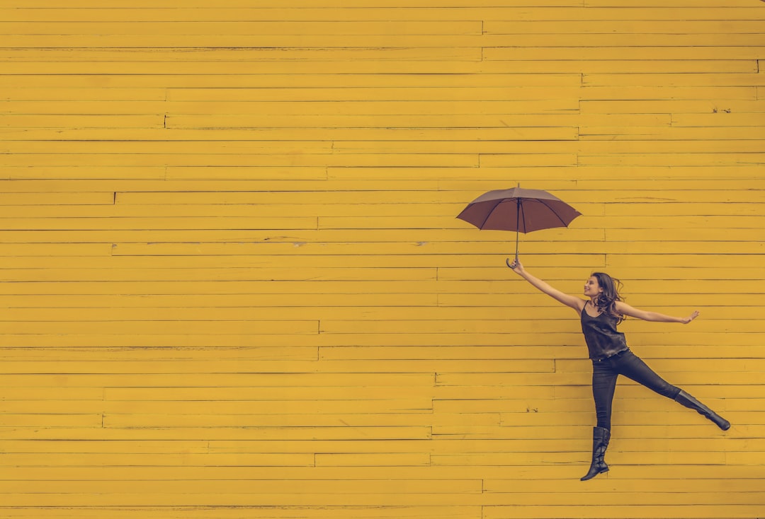 woman holding brown umbrella woman holding brown umbrella